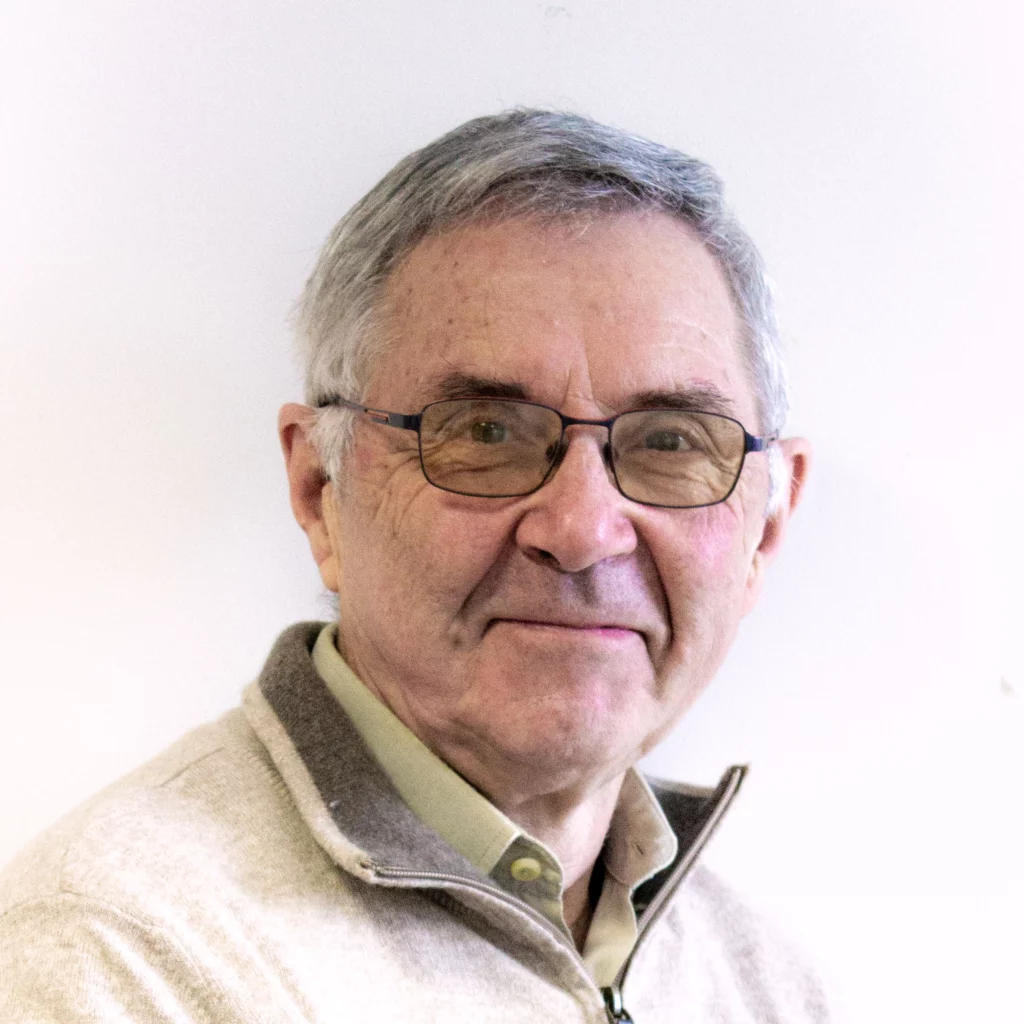 Homme aux cheveux gris et blancs, aux yeux marrons et lunettes noires.