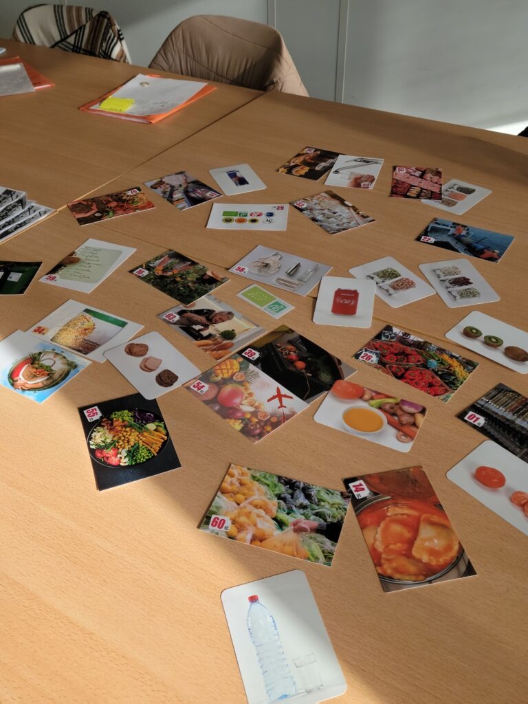 Des dizaines de cartes posées sur une table, montrant de la nourriture.
