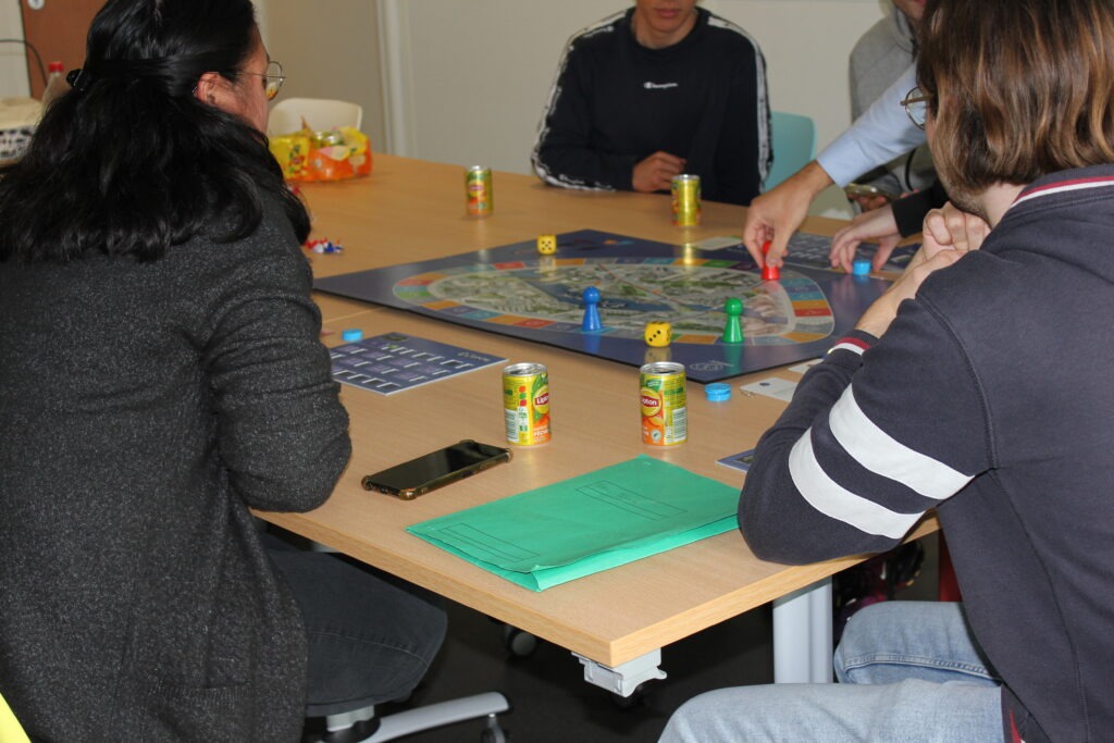 Un groupe de jeunes jouant à un jeu de plateau autour d'une table.