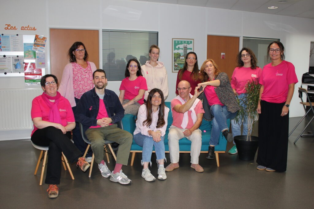 L'équipe de la Mission Locale autour du canapé de l'accueil, habillée en rose.