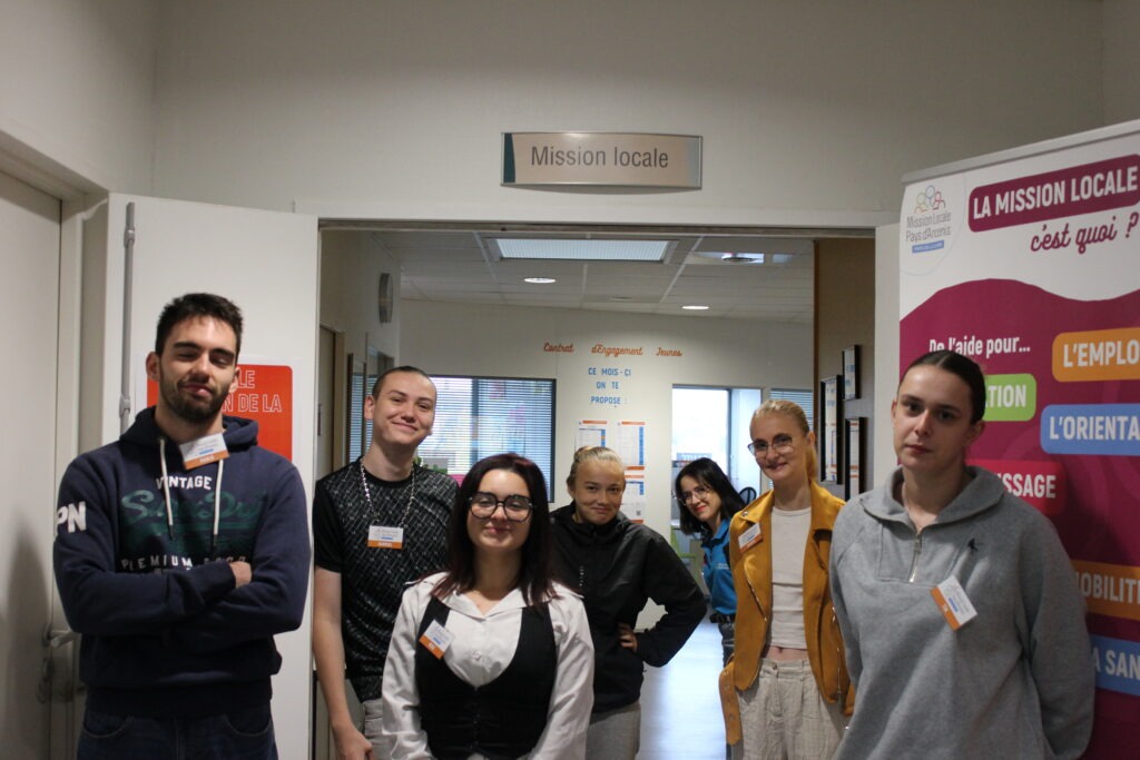 Groupe de jeunes devant l'entrée de la Mission Locale avec des badges à leur nom.
