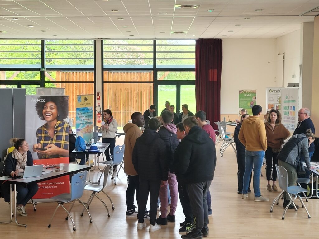 Plusieurs groupes de personnes discutant dans une salle d'évènement.