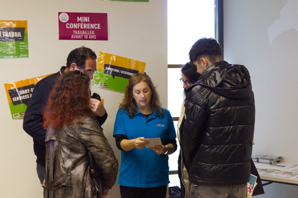 Une conseillère discutant avec quatre personnes debout.