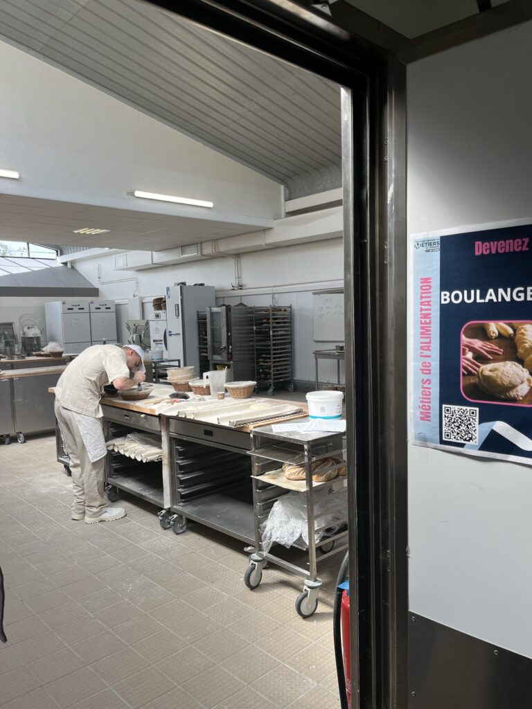 Un cuisiner travaillant dans la cuisine d'une boulangerie.