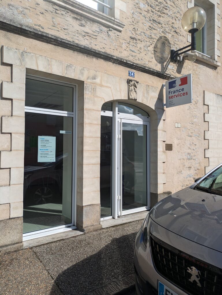Deux portes blanches dans un mur beige avec un logo "France services".