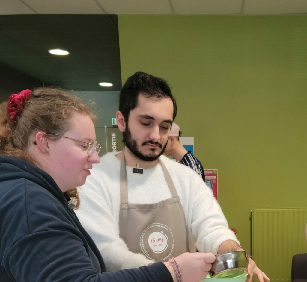 Deux jeunes et une partenaire faisant la cuisine.