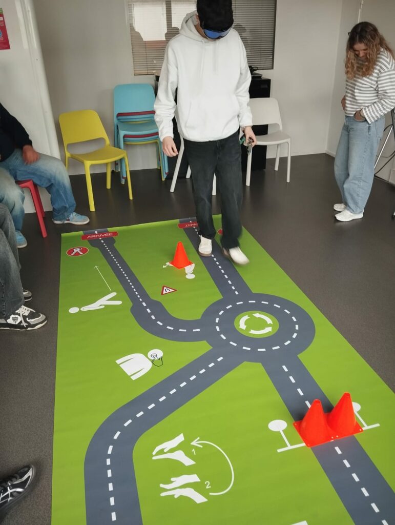 Jeune marchant sur un tapis avec une route et des plots de chantier.