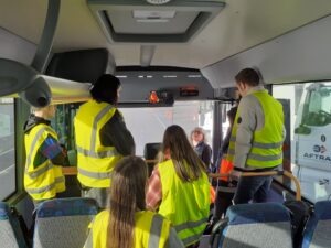 Un groupe de jeunes avec des gilets jaunes dans un car.