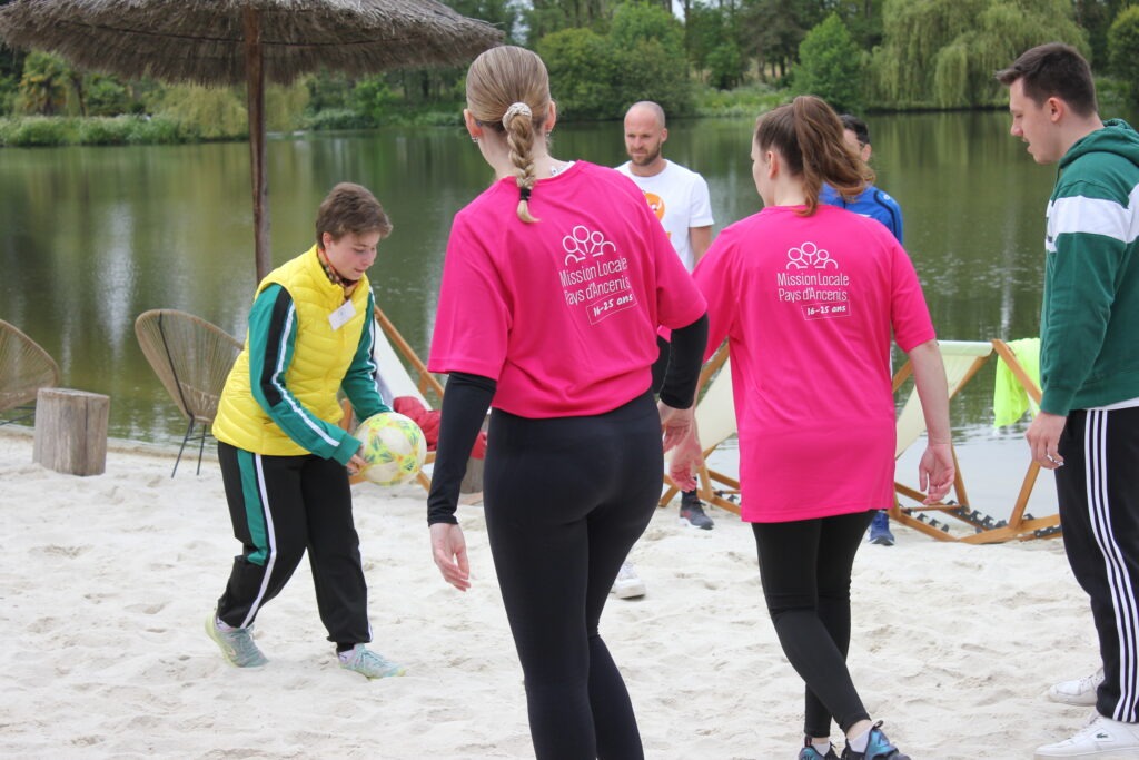Groupe de personnes jouant au foot, certaines avec des t-shirts roses marqués Mission Locale.