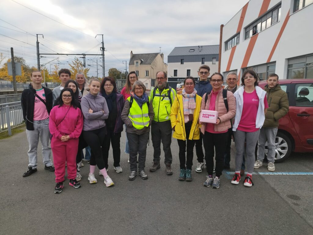 Groupe de jeunes et partenaires devant l'espace Corail, en rose.